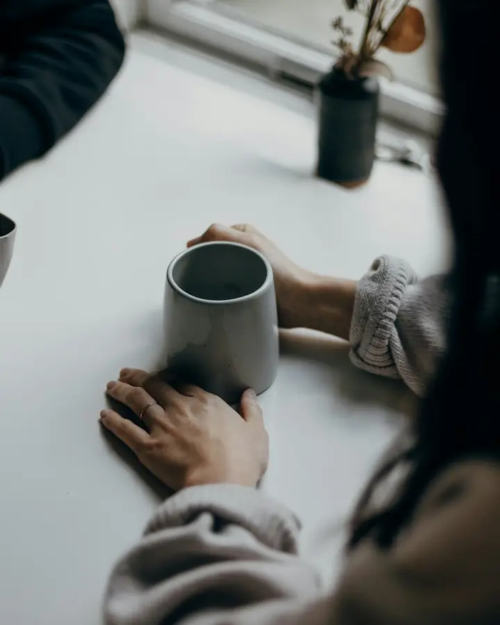 Dos personas en una pausa con una taza de café, con luz natural