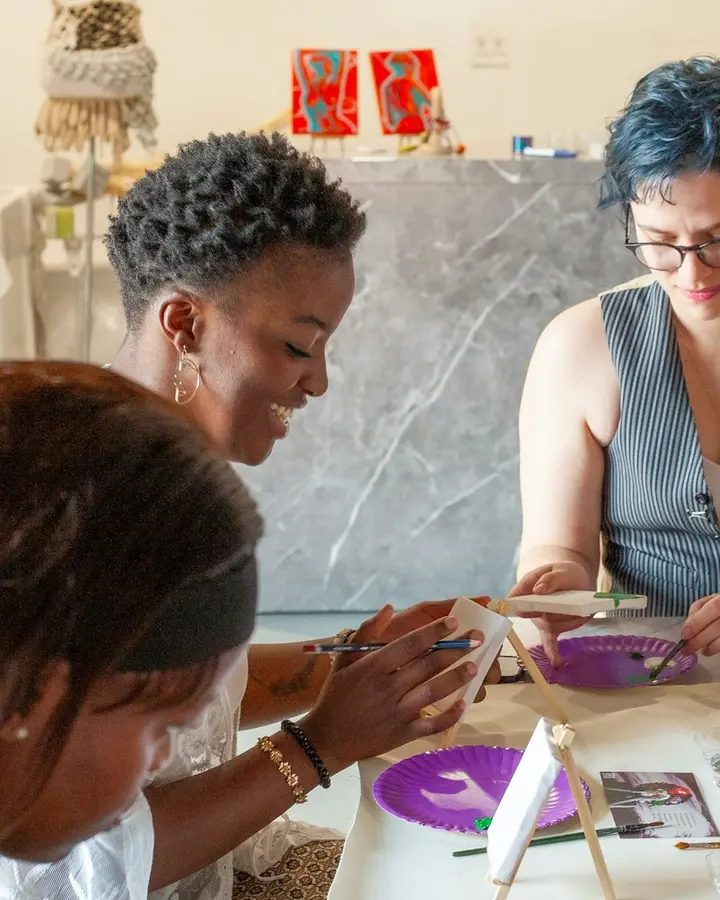 Personas pintando con acuarelas alrededor de una mesa durante un taller