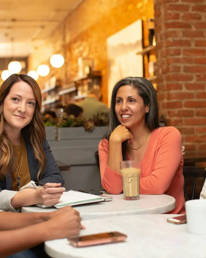 Grupo de mujeres conversando alrededor de una mesa